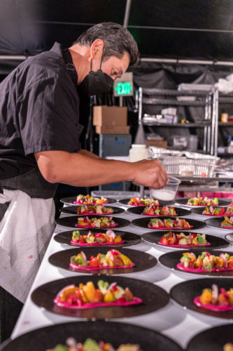 A Savore chef preparing individual plates for the Savore Culinary Hermes Event.