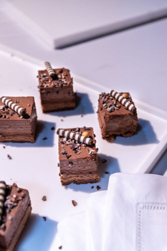 Small chocolate dessert cakes on a serving tray.