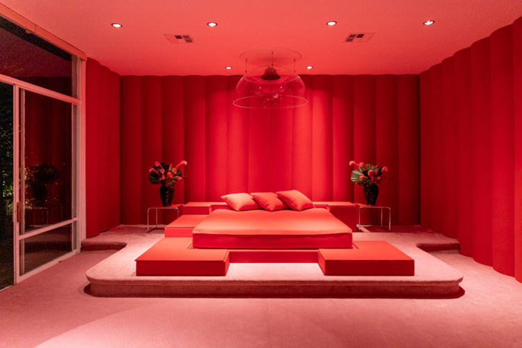A bedroom photographed under red lights.