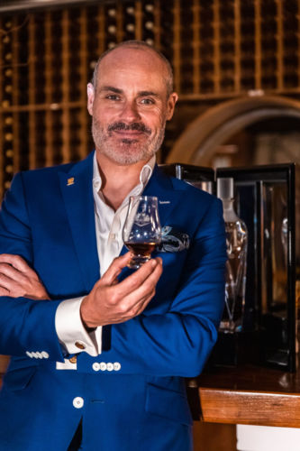 The Macallan photographed with a man in a blue suit.