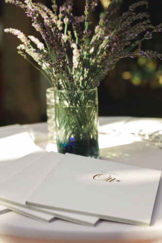 Domaines Ott white invitations by a vase of lavender.