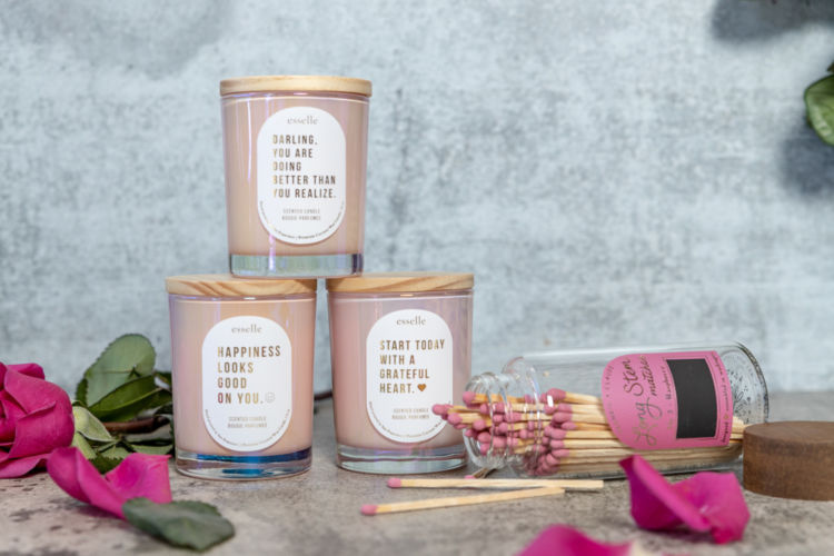 Three candle jars and matches photographed with rose petals and leaves.