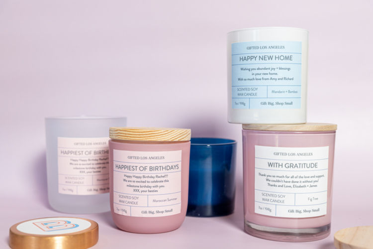 Different candles from Gifted LA photographed on a light lilac wall.