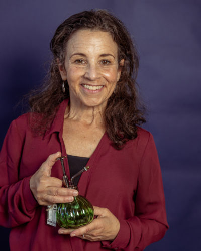 A woman holding a green jar.