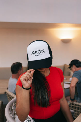 A woman wearing a black and white cap embossed with the Avion.